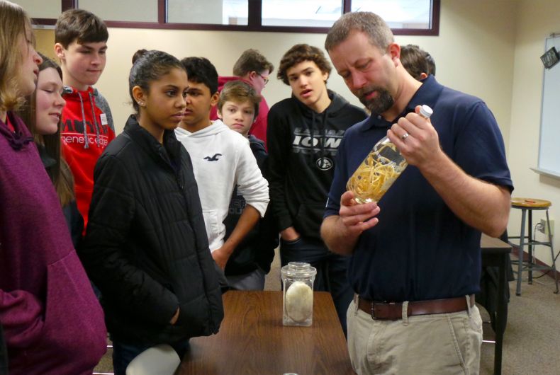 A man holding a bottle with a mystery substance inside