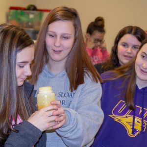thumbnail image of Kids checking out a bottle of something during a career fair