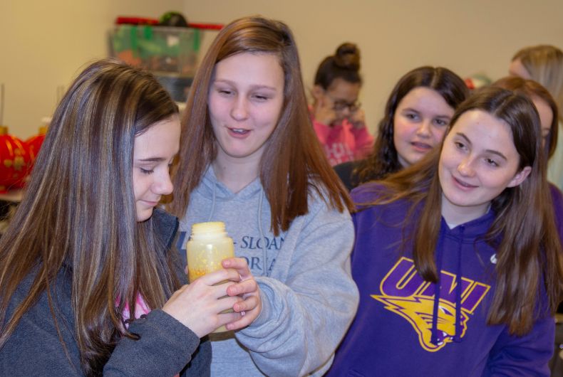 Kids checking out a bottle of something during a career fair