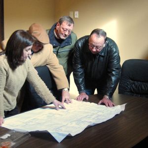 thumbnail image of Four people looking over a map on a table
