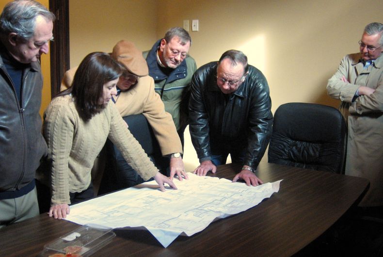 Four people looking over a map on a table