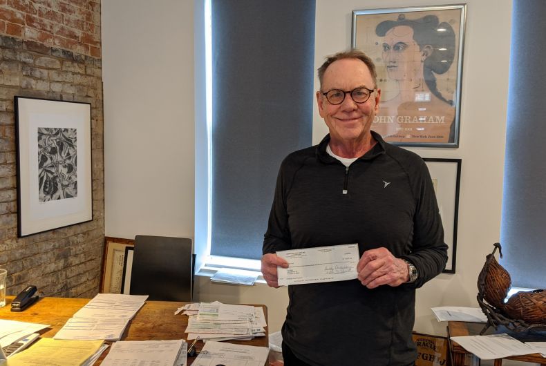 A man holding a check